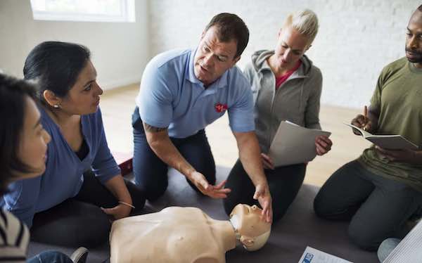 Instructor explaining CPR on CPR dummy
