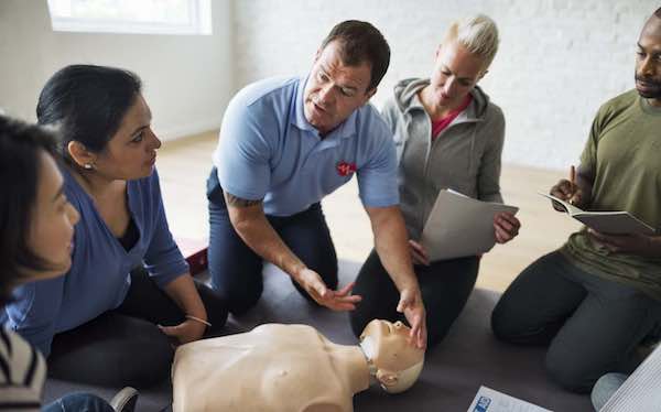 EFAW-crop Instructor explaining CPR on CPR dummy